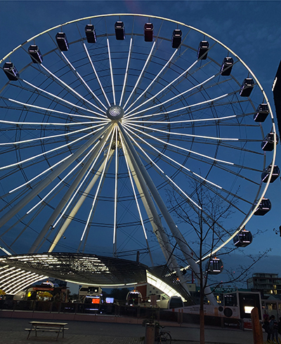 Das beleuchtete Riesenrad bei Einbruch der Dämmerung