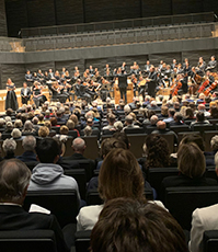 Blick auf die Bühne der Isarphilharmonie mit Musikern und Dirigenten