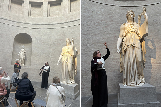 Die Gruppe mit der Kunstvermittlerin betrachtet die monumentale Statue des Apollon, hier den Gott als Musenführer im bodenlangen Peplos und mit Rückenmantel