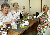 3 Frauen fröhlich am Kaffeetisch