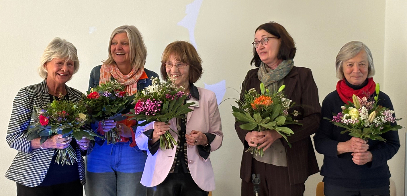 Gruppenbild mit lachenden Frauen: den Vorständinnen und Dr. Angela Lang und Mitfrau Maria mit Blumensträußen