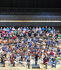 Blick auf die Bühne der Isarphilharmonie mit Musikern und Dirigenten