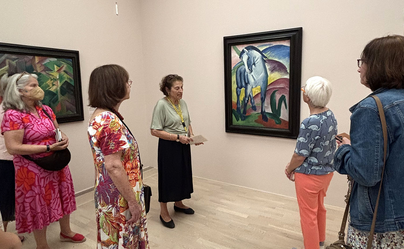 Die Ausstellungsbesucherinnen mit der Kunstvermittlerin Dr. Katia Marano vor dem blauen Pferd von Franz Marc