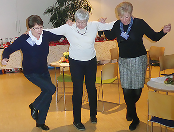3 Wohnfrauen tanzen zusammen Sirtaki