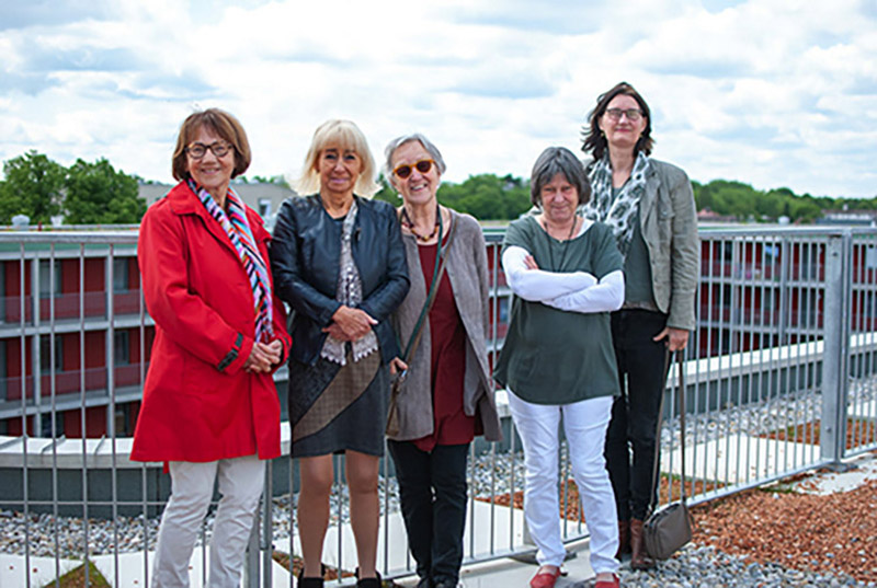 Blick in die Kamera: Die Wohnfrauen von WG 6 auf dem begrünten Dach der Wohnanlage Dante 2