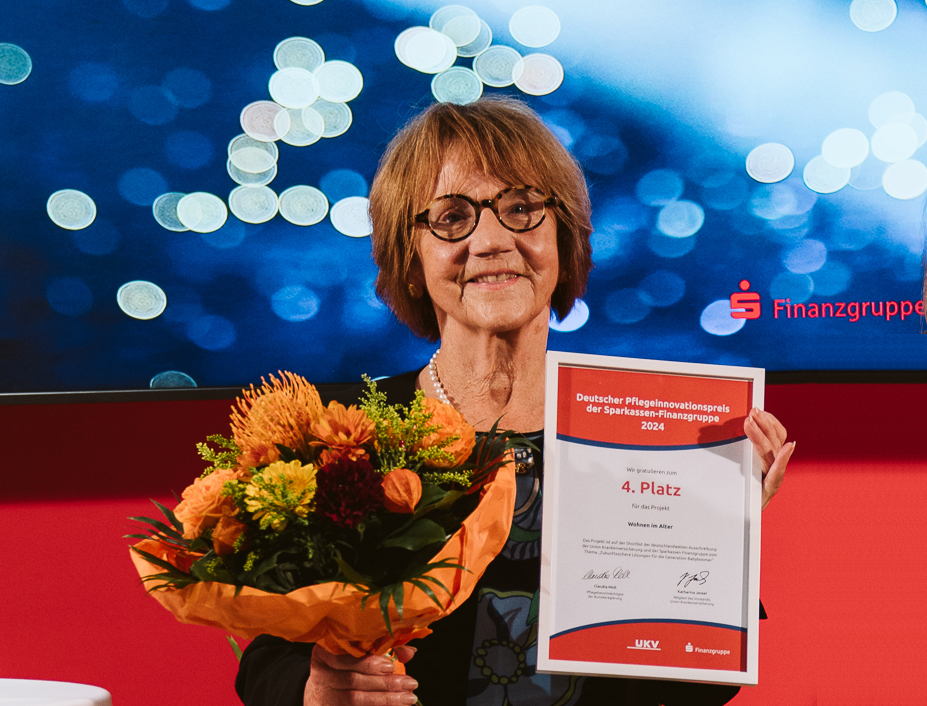 Dr. Christa Lippmann mit Blumenstrauss und Urkunde