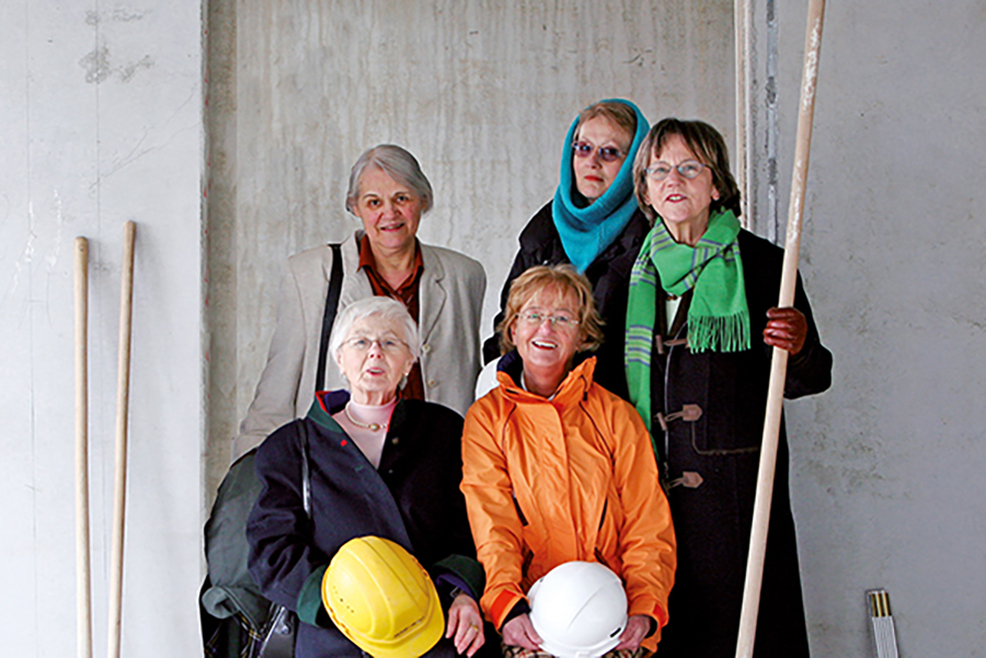 Pionierinnen der ersten Stunde: 5 Frauen mit Besen und Bauhelm, voll Erwartung
