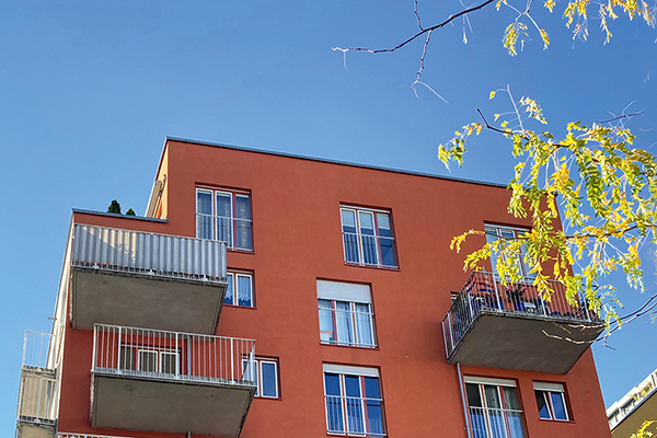 Blick auf die orangerote Fassade mit Balkonen