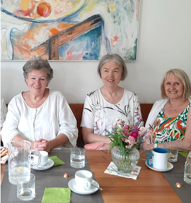 3 Frauen von Wohngruppe 5 mit gedeckter Kaffeetafel im Gemeinschaftsraum