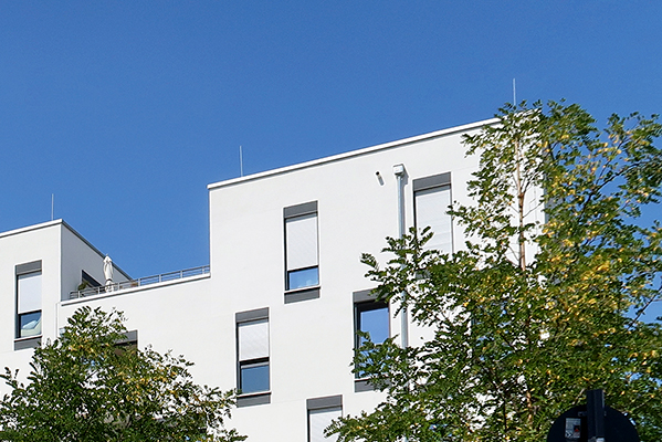 Blick auf die weisse Aussenfassade mit hohen Fenstern von Wohnprojekt 5