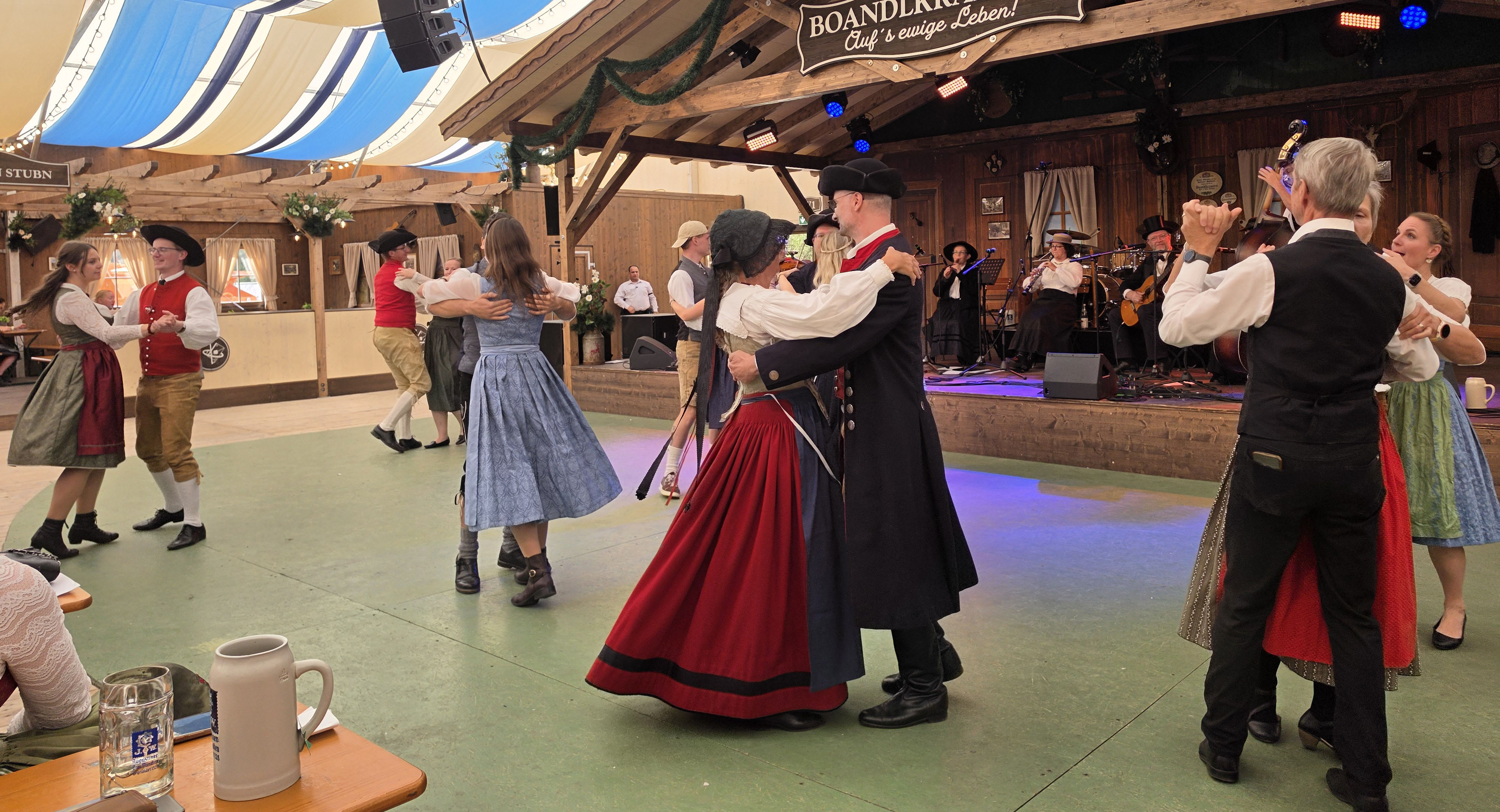 Tänzer in Lederhosen, Dirndl und Uniformen